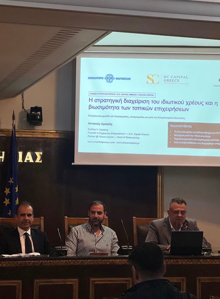 Τρεις άνδρες σε πάνελ με λογότυπα ιδρυμάτων σε επαγγελματική συνεδριακή αίθουσα
